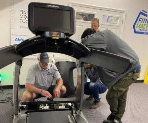 Men fixing a treadmill